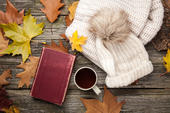 Buch, Tasse, Mütze und Herbstlaub